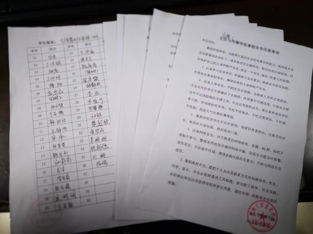 学生在《暑假安全注意事项》上签字