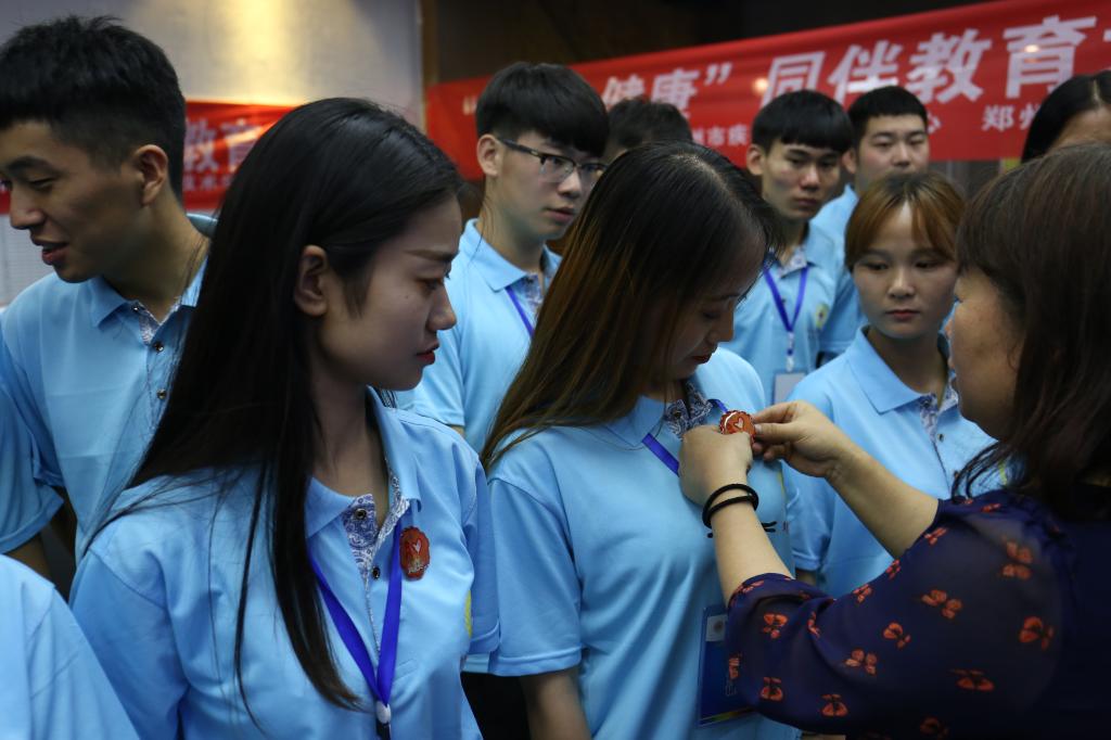 郑州市疾病预防控制中心刘征所长为学生佩戴防艾志愿者徽章